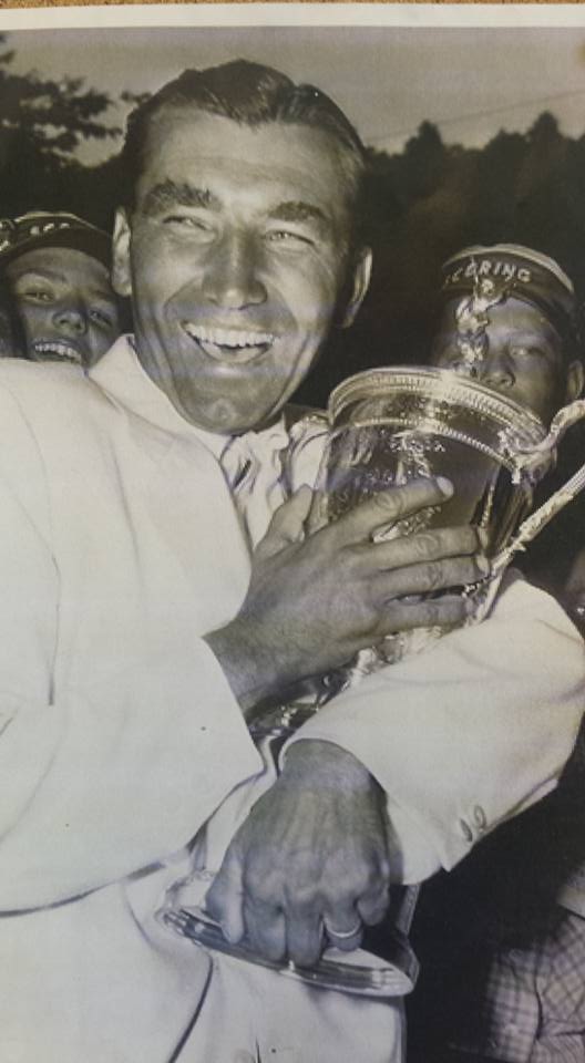 Cradled in his withered arm, Ed Furgol holds the U.S. Open trophy.